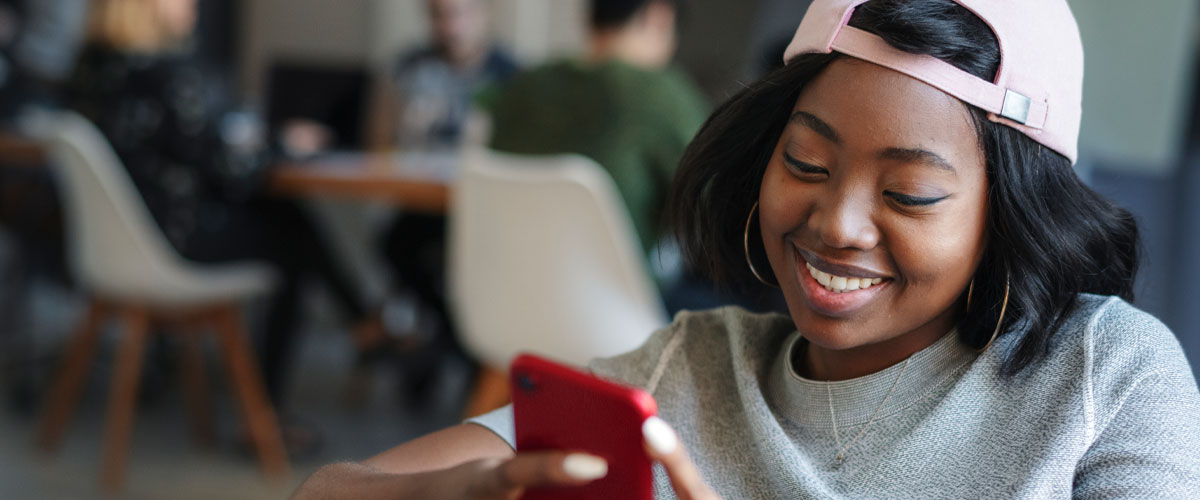 Student smiling while looking on phone